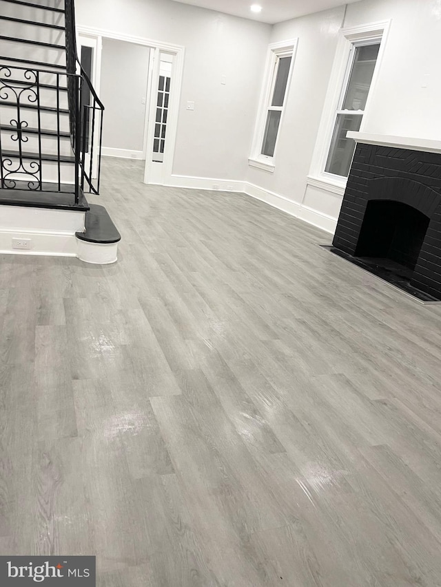 111 Oley St, Reading, PA 19601 - unfurnished living room with wood finished floors, stairway, baseboards, recessed lighting, and a fireplace