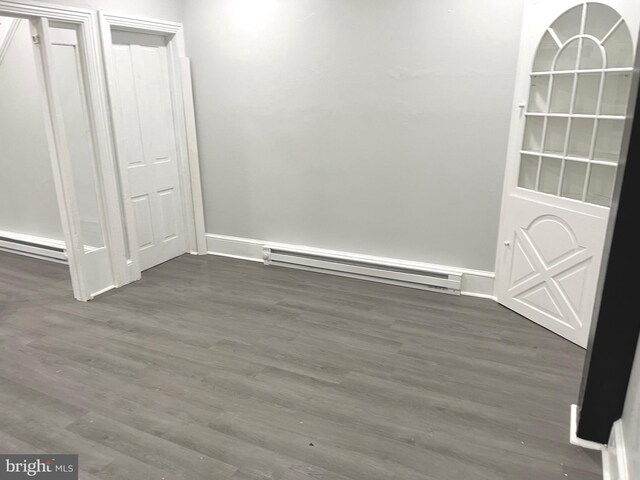 111 Oley St, Reading, PA 19601 - unfurnished dining area featuring a baseboard heating unit, wood finished floors, baseboards, and baseboard heating