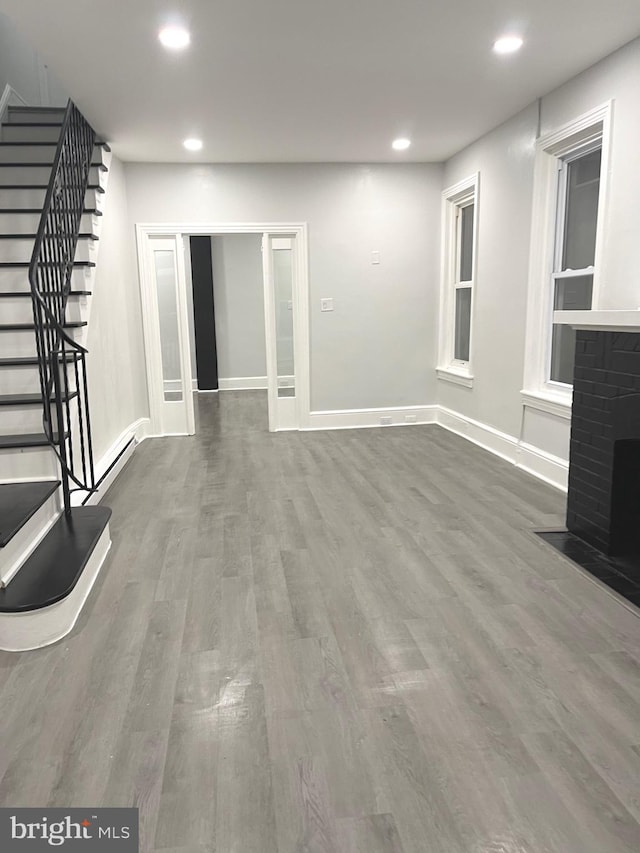 111 Oley St, Reading, PA 19601 - unfurnished living room with stairway, recessed lighting, wood finished floors, baseboards, and a fireplace