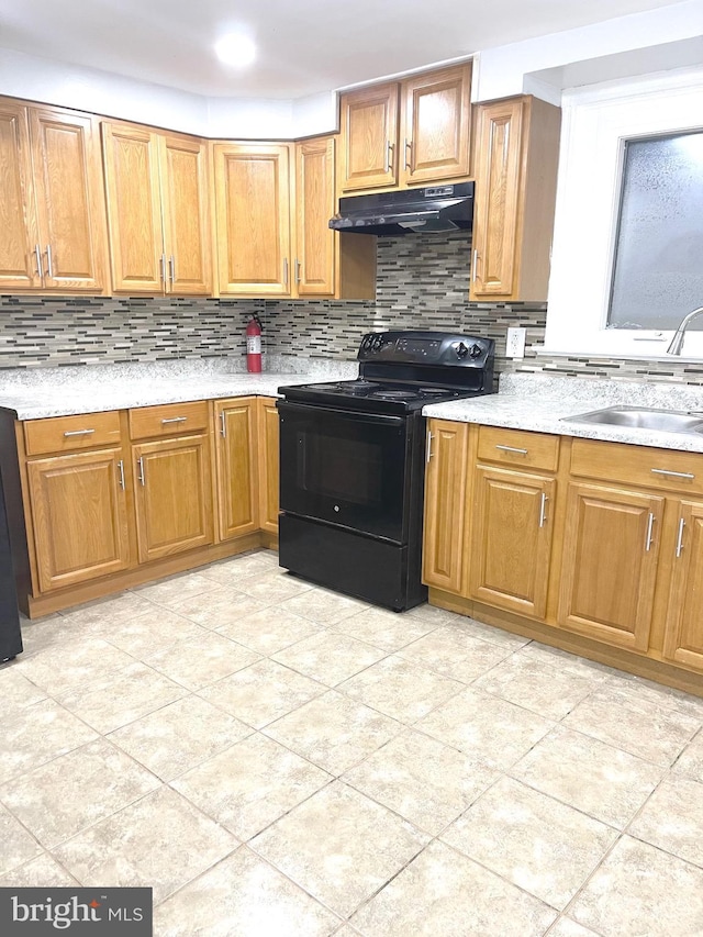 111 Oley St, Reading, PA 19601 - kitchen featuring black electric range oven, under cabinet range hood, a sink, tasteful backsplash, and light countertops