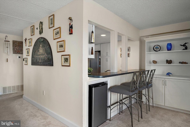 11000 Coastal Hwy Unit 1211, Ocean City, MD 21842 - bar with freestanding refrigerator, light colored carpet, a textured ceiling, and baseboards