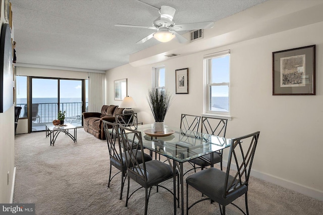 11000 Coastal Hwy Unit 1211, Ocean City, MD 21842 - carpeted dining area featuring a textured ceiling, a ceiling fan, a water view, and baseboards
