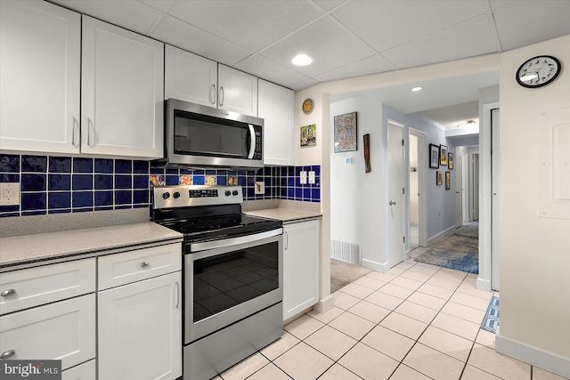 11000 Coastal Hwy Unit 1211, Ocean City, MD 21842 - kitchen featuring appliances with stainless steel finishes, white cabinets, baseboards, light tile patterned floors, and tasteful backsplash