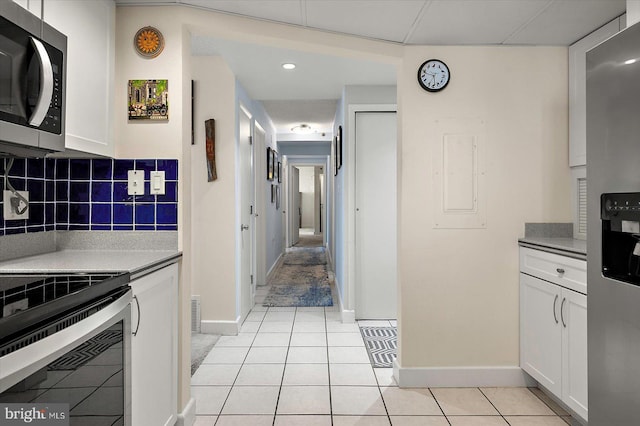 11000 Coastal Hwy Unit 1211, Ocean City, MD 21842 - kitchen featuring appliances with stainless steel finishes, backsplash, white cabinets, light tile patterned floors, and baseboards