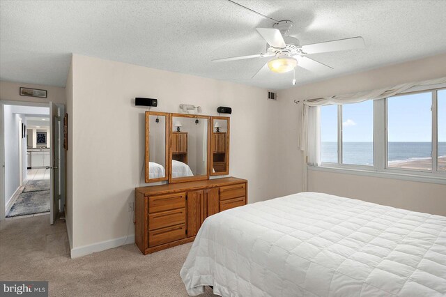 11000 Coastal Hwy Unit 1211, Ocean City, MD 21842 - bedroom with light colored carpet, a textured ceiling, a water view, baseboards, and ceiling fan