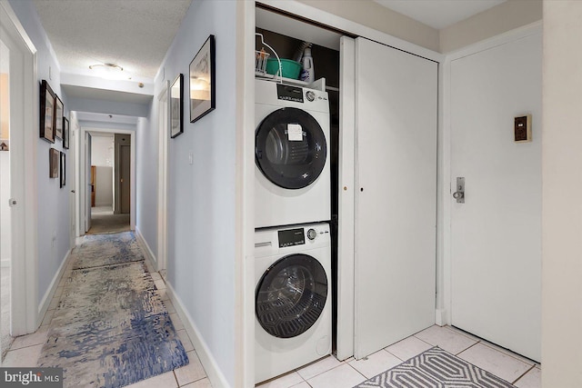 11000 Coastal Hwy Unit 1211, Ocean City, MD 21842 - laundry area featuring estacked washer and dryer, light tile patterned flooring, and a textured ceiling