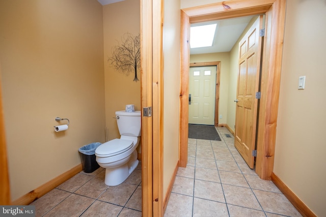 bathroom featuring toilet, baseboards, and tile patterned flooring