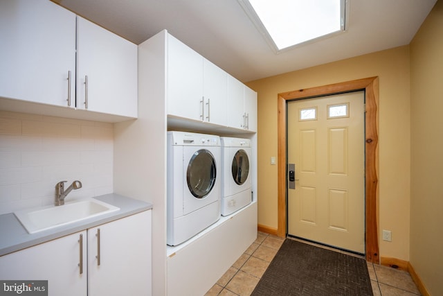 laundry room with independent washer and dryer, cabinet space, light tile patterned floors, and baseboards