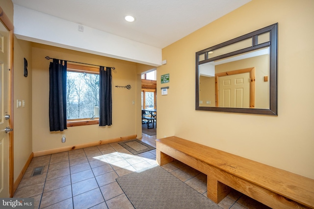 doorway to outside featuring tile patterned flooring, baseboards, and recessed lighting