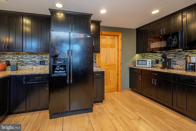 kitchen with black appliances, backsplash, light stone countertops, light wood-style flooring, and recessed lighting