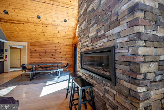living area featuring wood finished floors, lofted ceiling, and wood walls