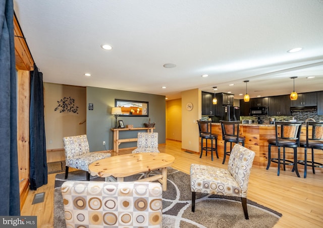 living area with light wood finished floors and recessed lighting