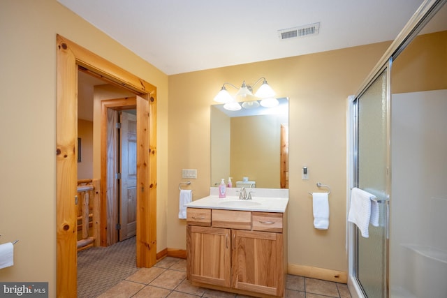 bathroom featuring a shower stall, vanity, tile patterned flooring, and baseboards