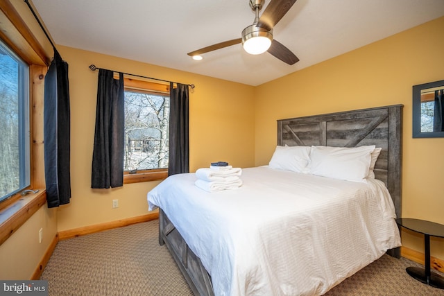 bedroom with multiple windows, baseboards, carpet flooring, and a ceiling fan
