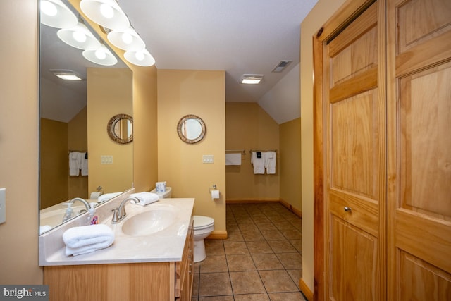 bathroom with lofted ceiling, toilet, vanity, tile patterned floors, and baseboards
