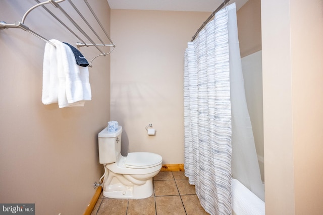 bathroom featuring baseboards, toilet, and tile patterned flooring