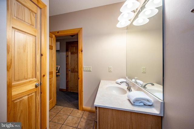 bathroom featuring a chandelier, tile patterned floors, vanity, and baseboards
