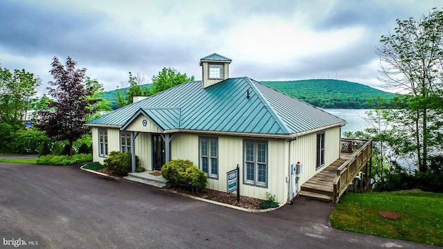 view of front of home featuring a standing seam roof, metal roof, and stairs