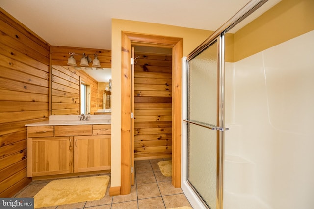 full bathroom with a stall shower, tile patterned flooring, wooden walls, and vanity