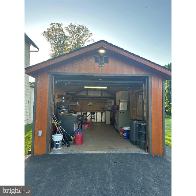 garage featuring asphalt driveway
