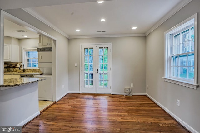 6630 Hillandale Rd Unit 56, Chevy Chase, MD 20815 - entryway with light wood-style floors, ornamental molding, estacked washer and dryer, baseboards, and french doors
