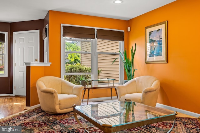 sitting room featuring baseboards, recessed lighting, and wood finished floors