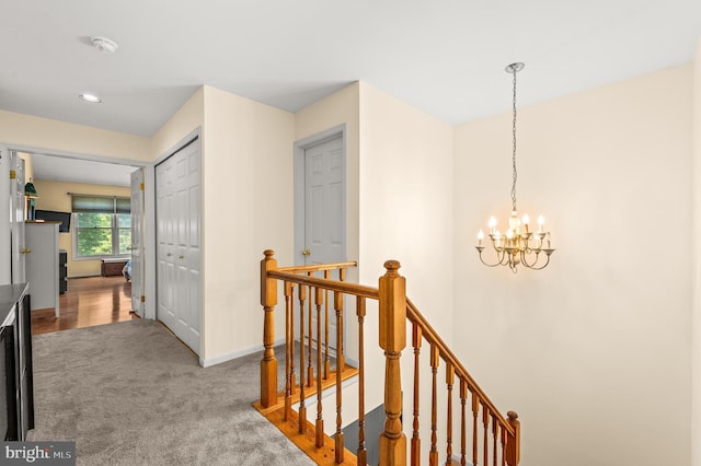hallway with an upstairs landing, a chandelier, carpet, baseboards, and recessed lighting