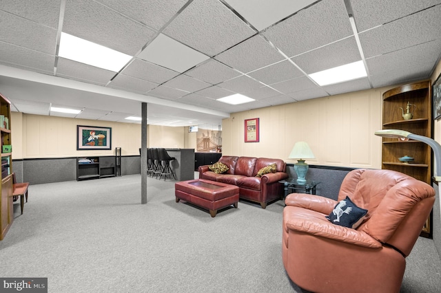 living room with a dry bar, a drop ceiling, and carpet floors