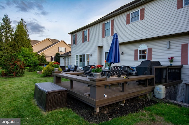 back of property with a lawn and a deck