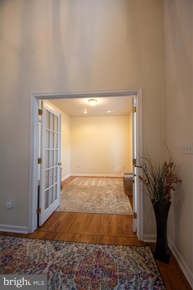 corridor with wood finished floors and baseboards