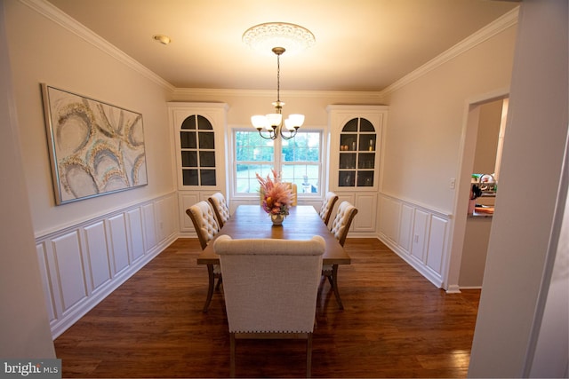dining area featuring a decorative wall, a chandelier, dark wood-type flooring, crown molding, and a wainscoted wall