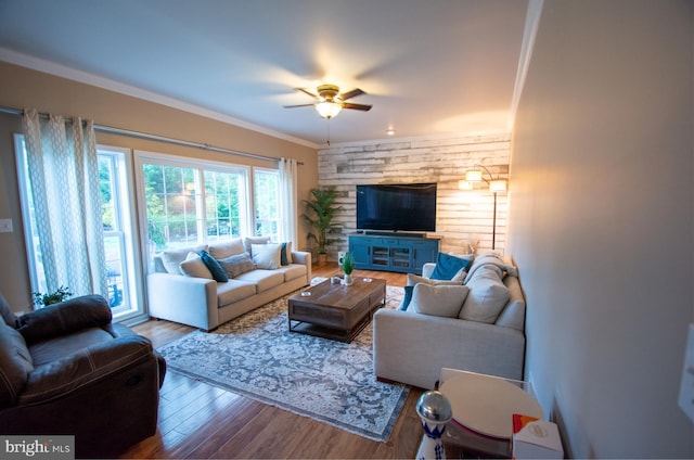 living area featuring a ceiling fan, wood finished floors, and crown molding