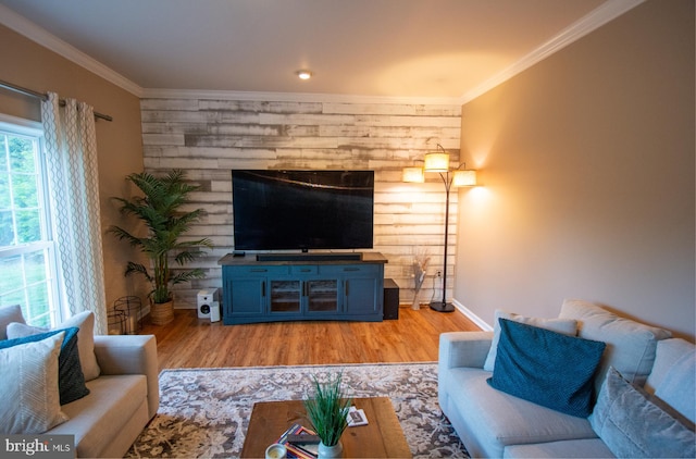 living room featuring light wood-type flooring, crown molding, and baseboards