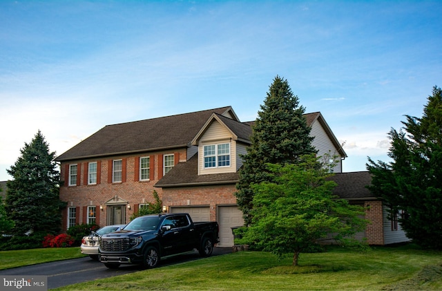 view of front of property featuring asphalt driveway, brick siding, a front lawn, and a shingled roof