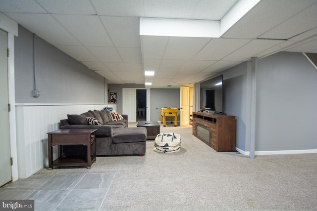 living area with a paneled ceiling and carpet