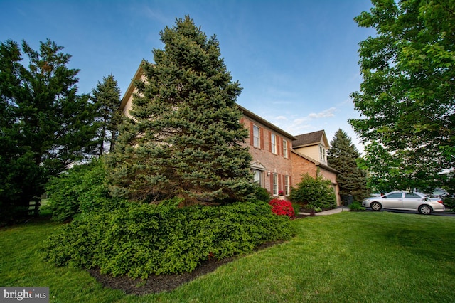 view of property exterior with a yard and brick siding