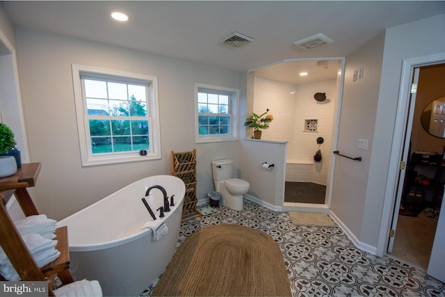 full bathroom featuring walk in shower, a freestanding bath, toilet, recessed lighting, and baseboards