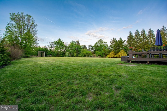 view of grassy yard with a deck