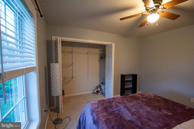 bedroom featuring light colored carpet, a closet, ceiling fan, and baseboards