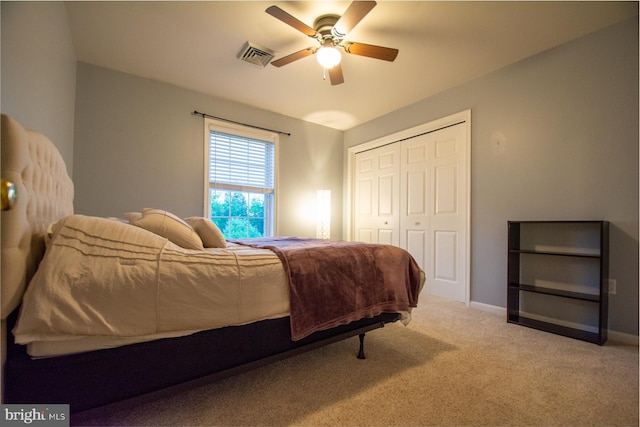 carpeted bedroom with a closet, baseboards, and ceiling fan