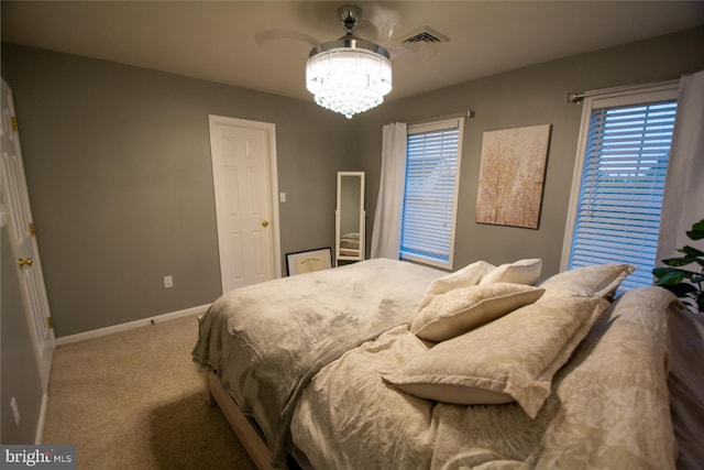 bedroom featuring a chandelier, carpet floors, and baseboards