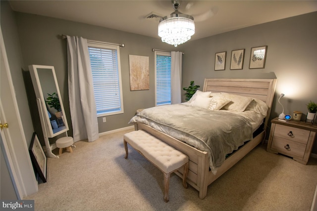 bedroom featuring light colored carpet, a chandelier, and baseboards