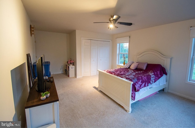 carpeted bedroom with a closet, baseboards, and a ceiling fan