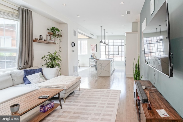 living area featuring light wood finished floors, recessed lighting, and baseboards