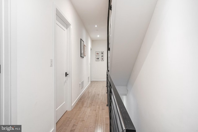 hallway featuring light wood-style flooring, recessed lighting, and baseboards