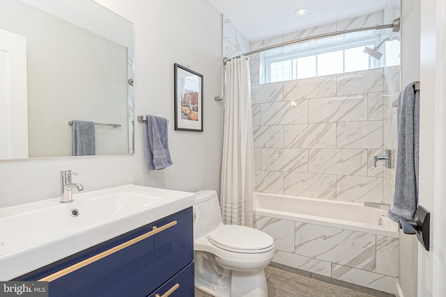 bathroom with tiled shower / bath, toilet, vanity, wood finished floors, and recessed lighting