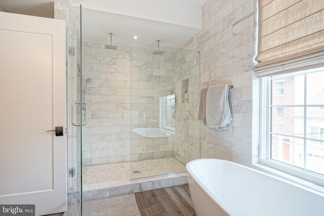 bathroom featuring a stall shower, a freestanding bath, wood finished floors, and recessed lighting