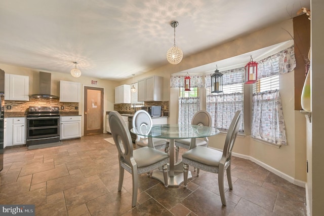 dining space featuring baseboards and stone tile floors