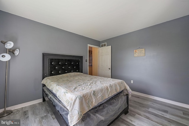 bedroom featuring baseboards and wood finished floors