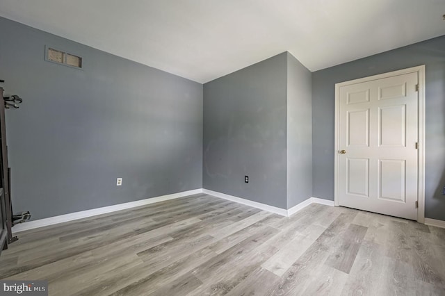 unfurnished room with wood finished floors and baseboards